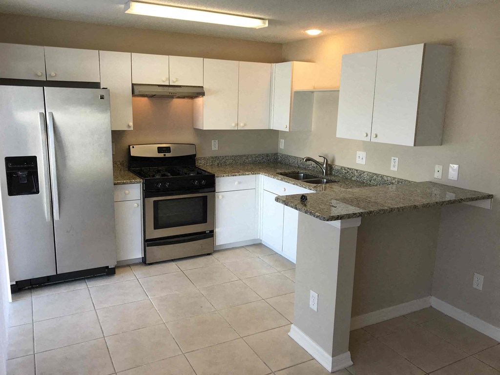 A kitchen with a granite countertop and stainless steel appliances.