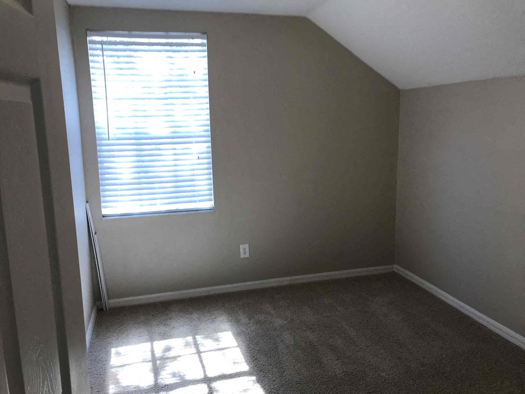 A room with a window and sunlight shining through.