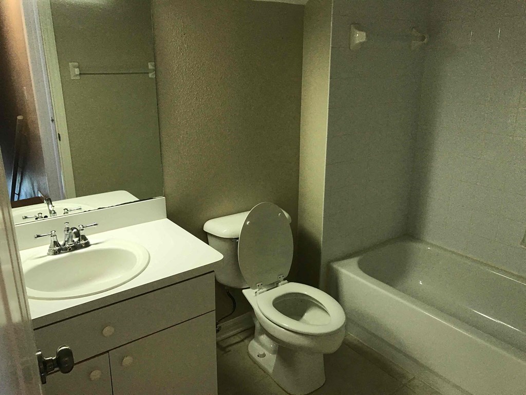 A bathroom with a toilet, sink, and bathtub.