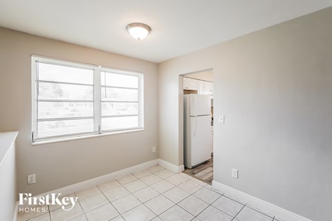 A room with a window and a door leading to another room.