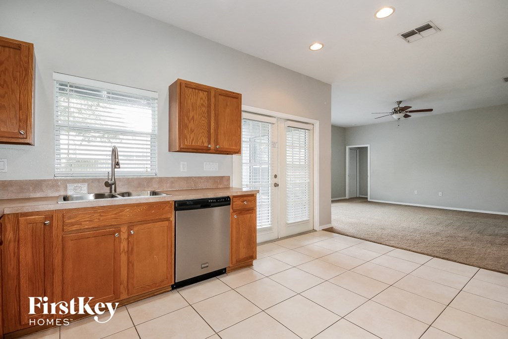 A kitchen with wooden cabinets and a tile floor.