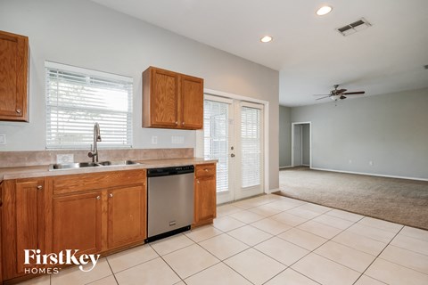 A kitchen with wooden cabinets and a tile floor.