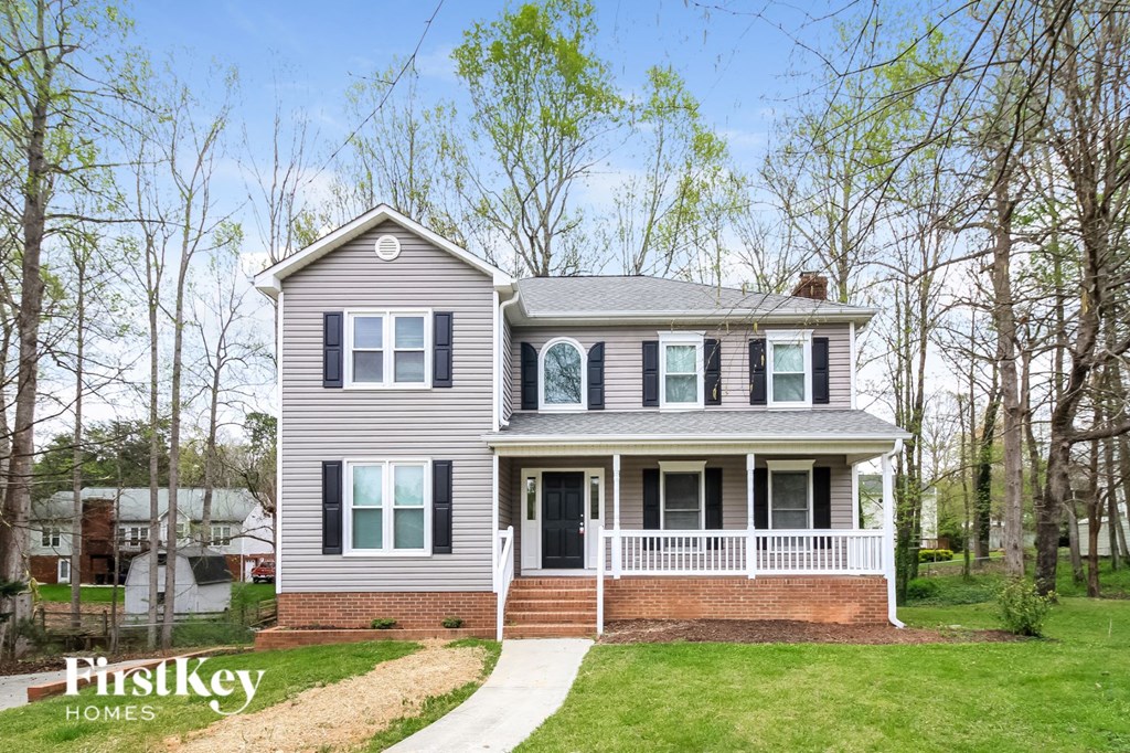 a with a white front porch and a lawn