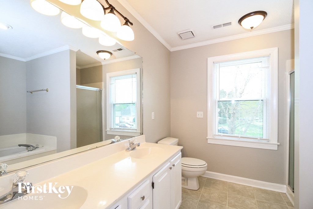 a bathroom with a large mirror and a sink and a toilet