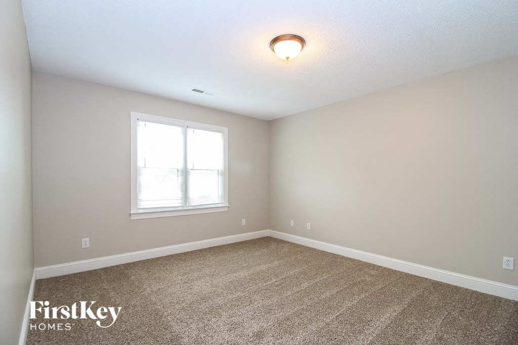 the second bedroom is spacious and has carpeting and a window