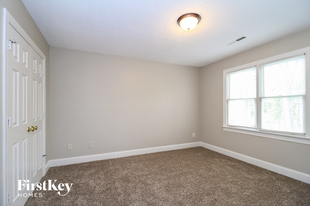 a bedroom with a carpeted floor and a large window