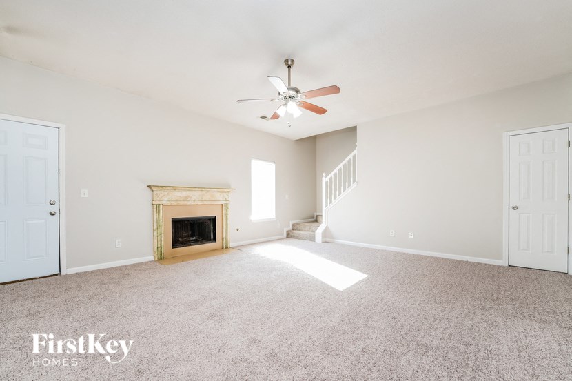 a living room with a fireplace and a ceiling fan