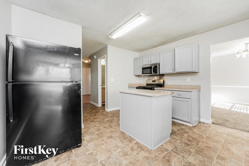 a kitchen with white cabinets and a stainless steel refrigerator