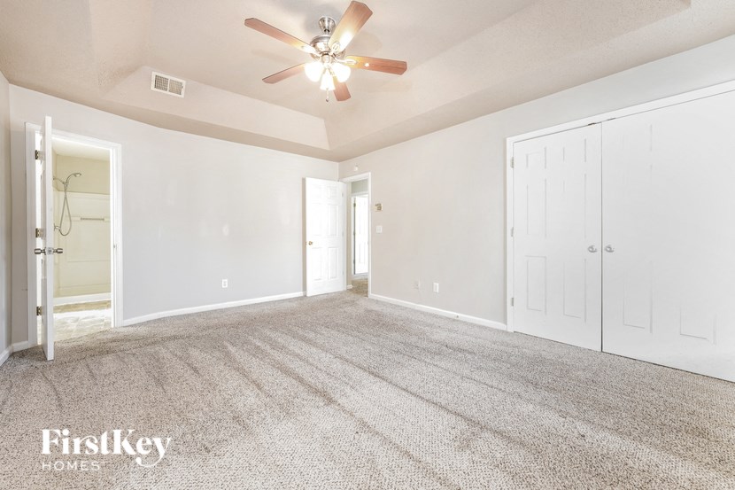 a living room with carpet and a ceiling fan