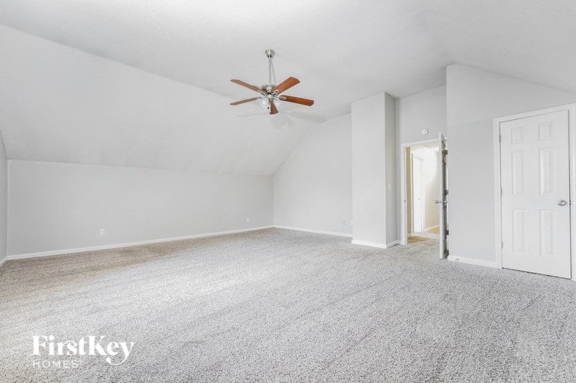 a white room with a ceiling fan and a white door