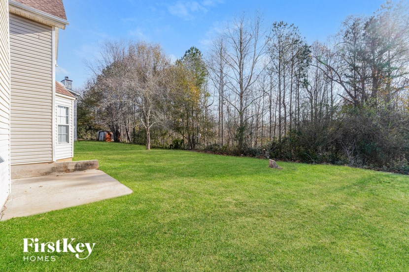 a backyard with a yard and a house and some trees