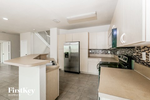 A kitchen with a refrigerator, stove, and oven.