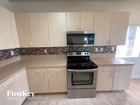 A kitchen with a stove top oven and microwave above it.