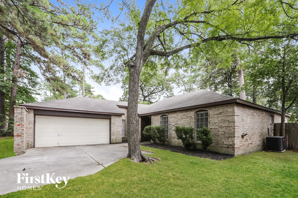 a brick house with a garage and a tree