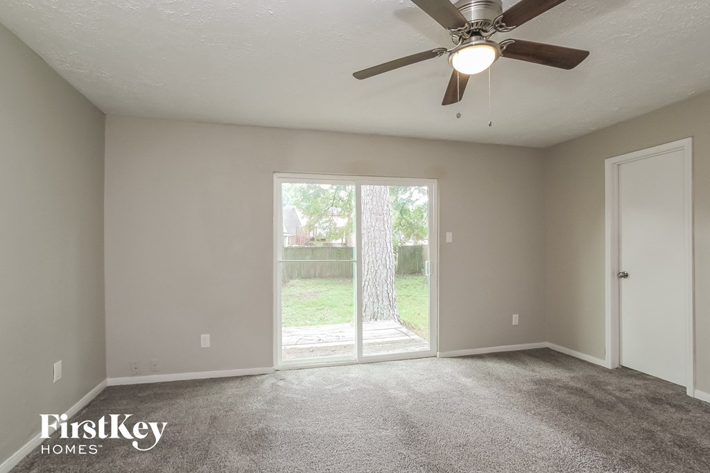 the living room of an empty house with a ceiling fan