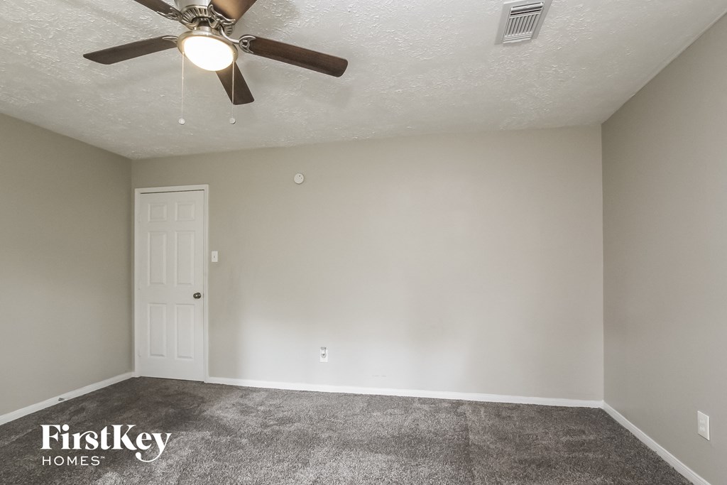 the living room of an empty house with a ceiling fan