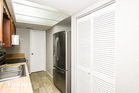 a kitchen with a stainless steel refrigerator and a sink