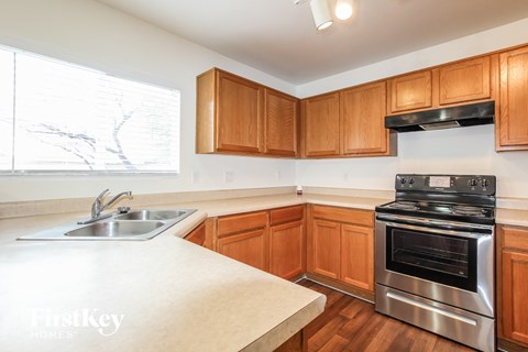 A kitchen with wooden cabinets and a stainless steel oven.