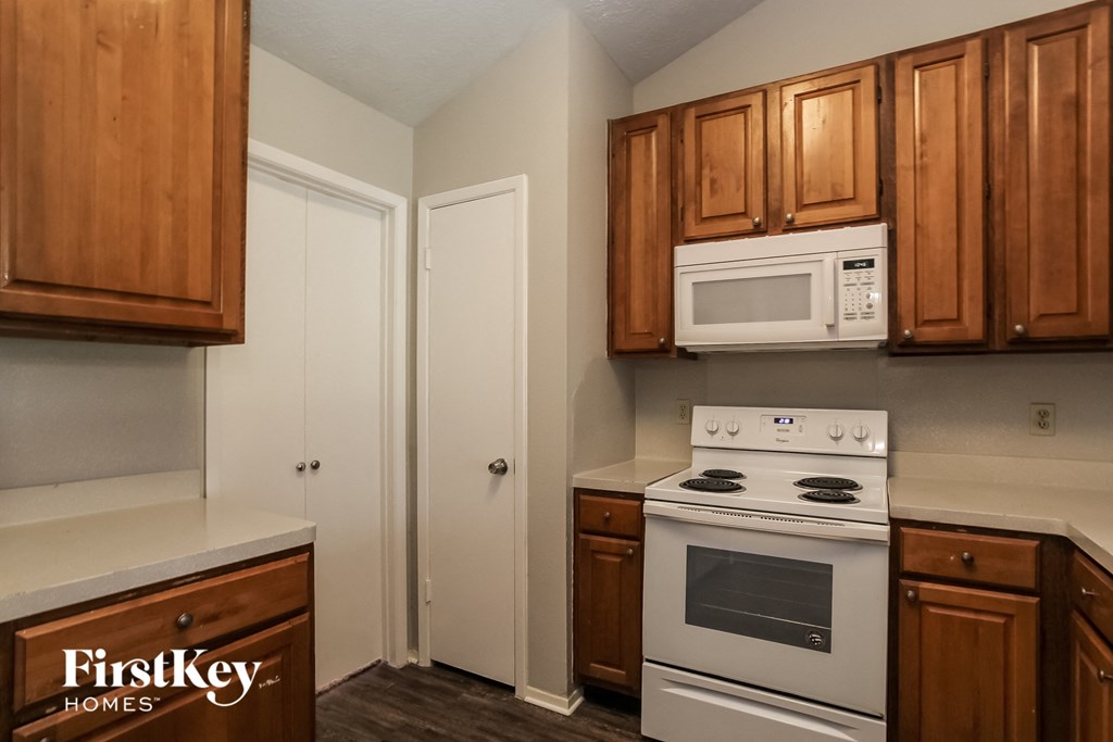a kitchen with a stove and a microwave and wooden cabinets