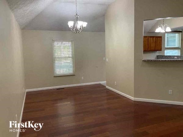 A room with wooden floors and a chandelier.