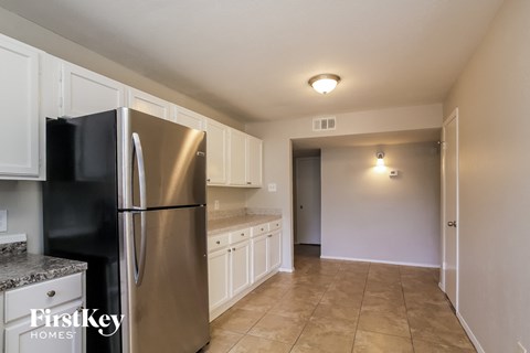 a kitchen with white cabinets and a stainless steel refrigerator