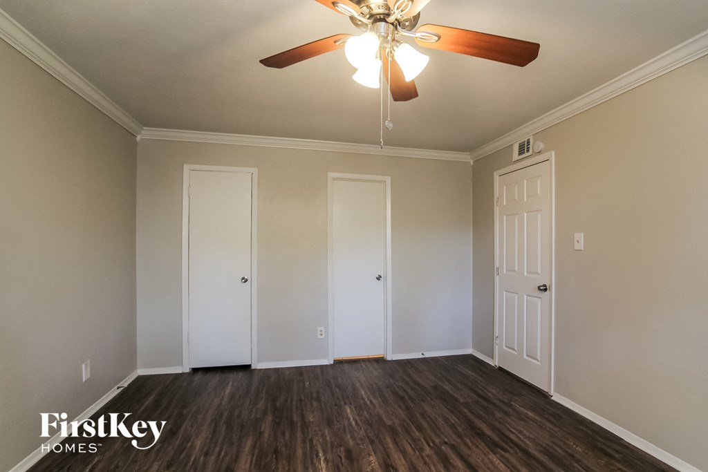 a living room with a ceiling fan and white doors