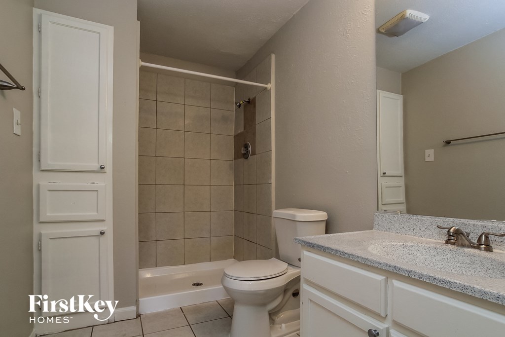 a bathroom with a toilet and a shower and a sink