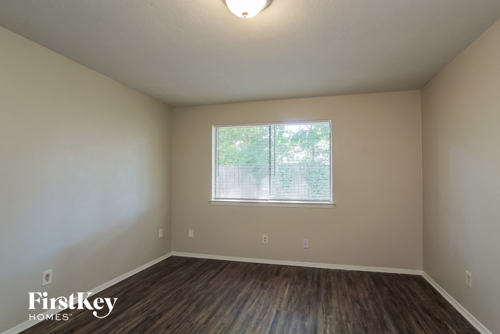 the interior of an empty room with wood floors and a window