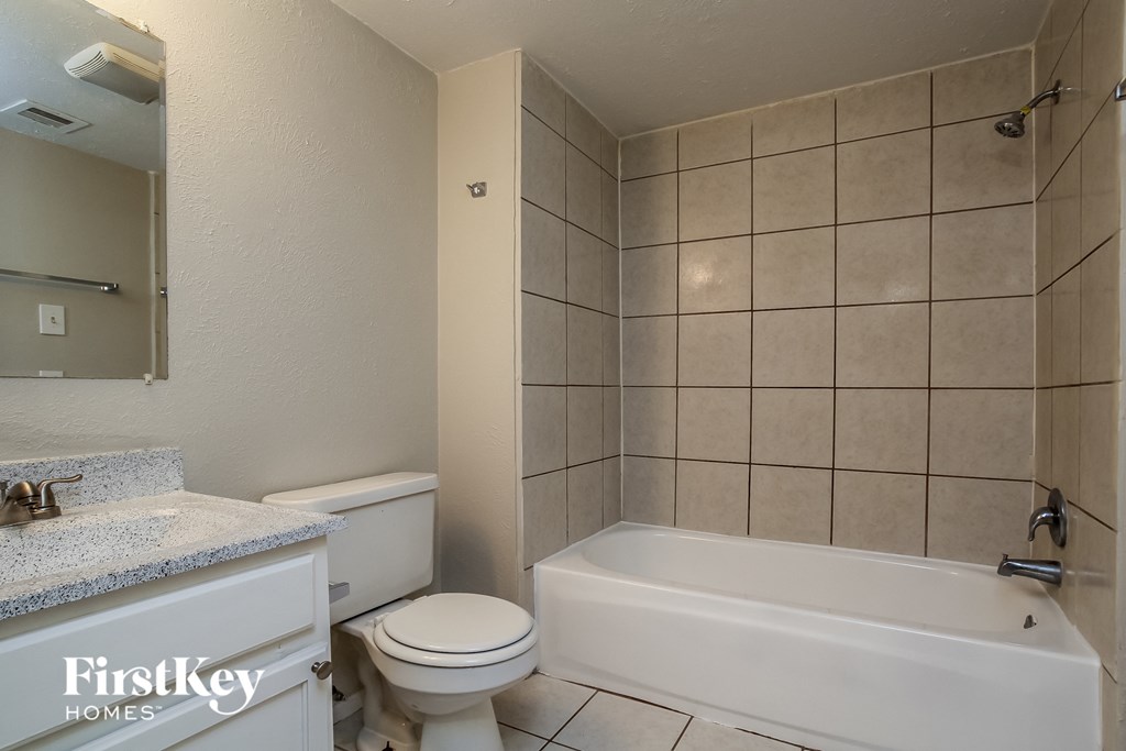 a bathroom with a toilet and a tub and a sink