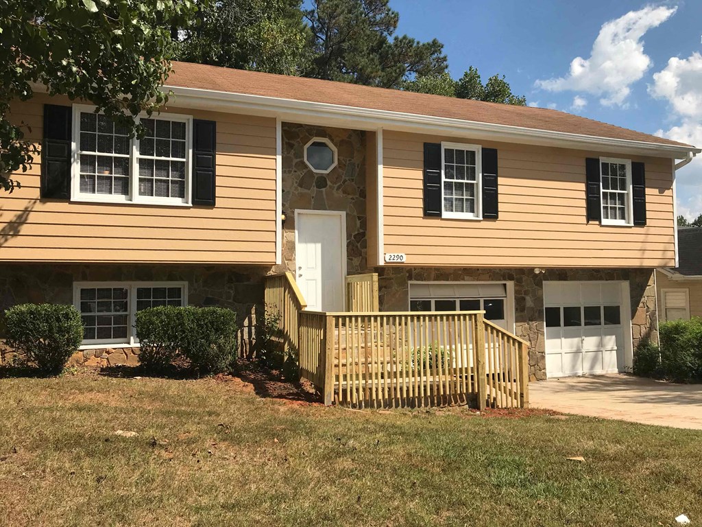 A two-story house with a white door and windows.