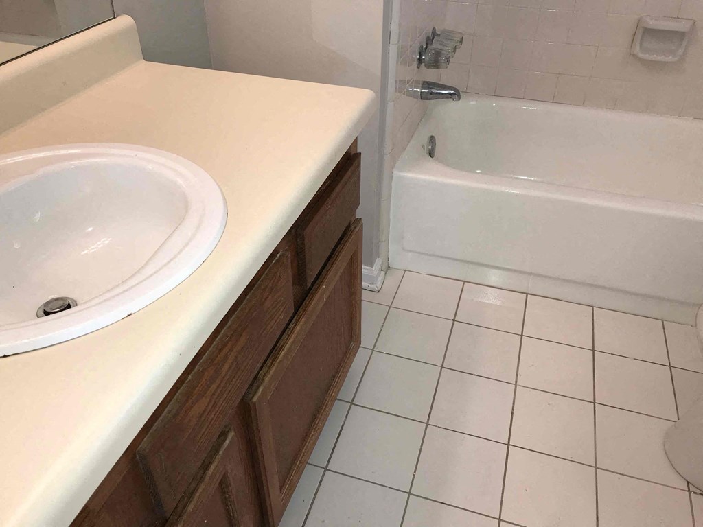 A white bathroom with a sink and a bathtub.