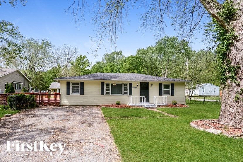 A house with a gravel driveway in front of it.