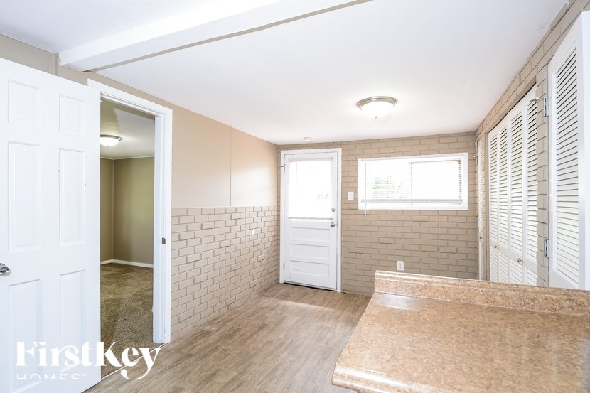 A room with a white door and a window with blinds.
