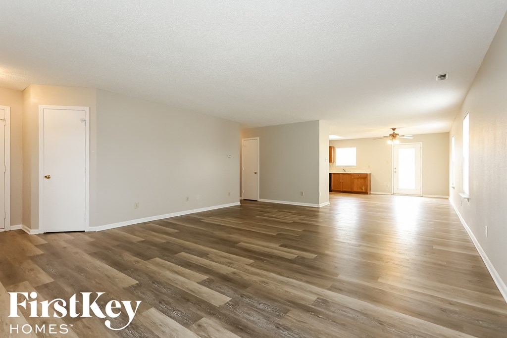 the living room and dining room of an empty house with wood floors