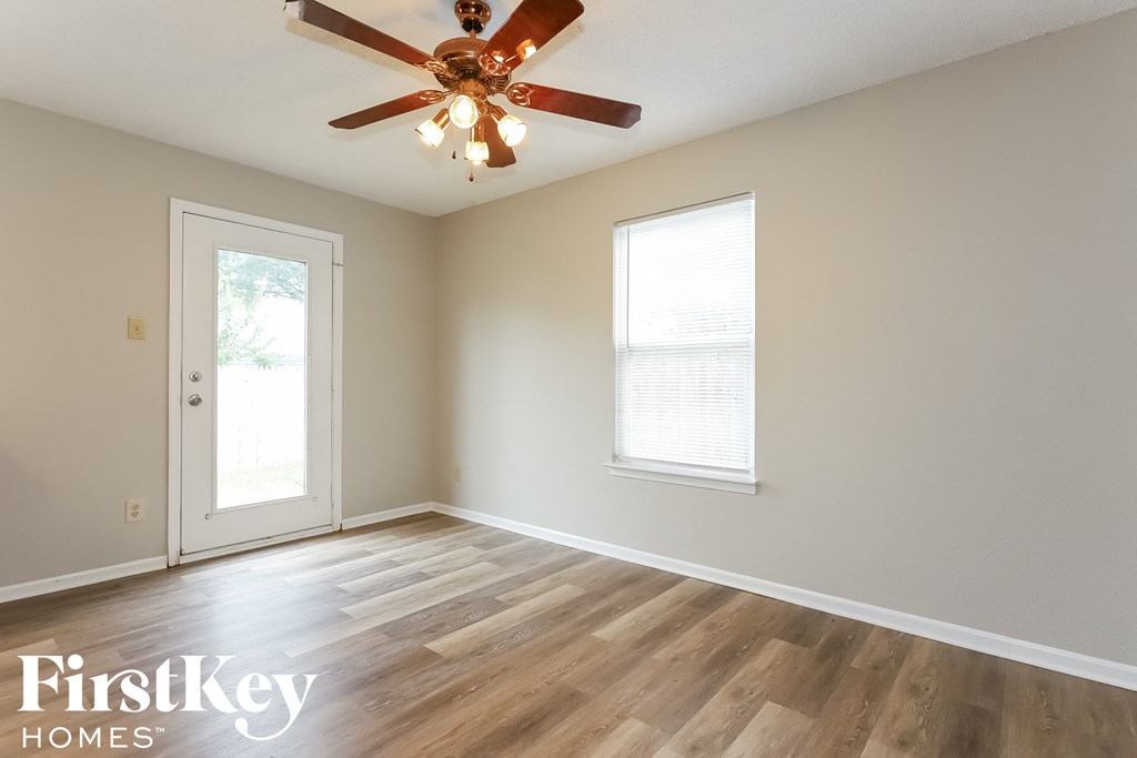 a living room with wood floors and a ceiling fan