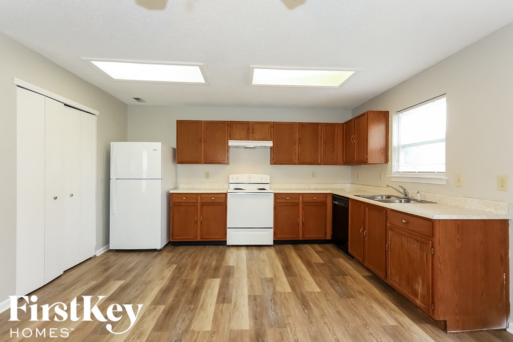 an empty kitchen with wooden cabinets and white appliances