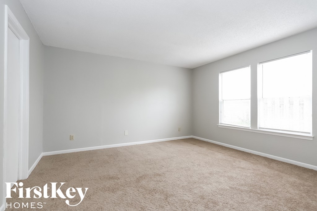 a bedroom with a carpeted floor and two windows