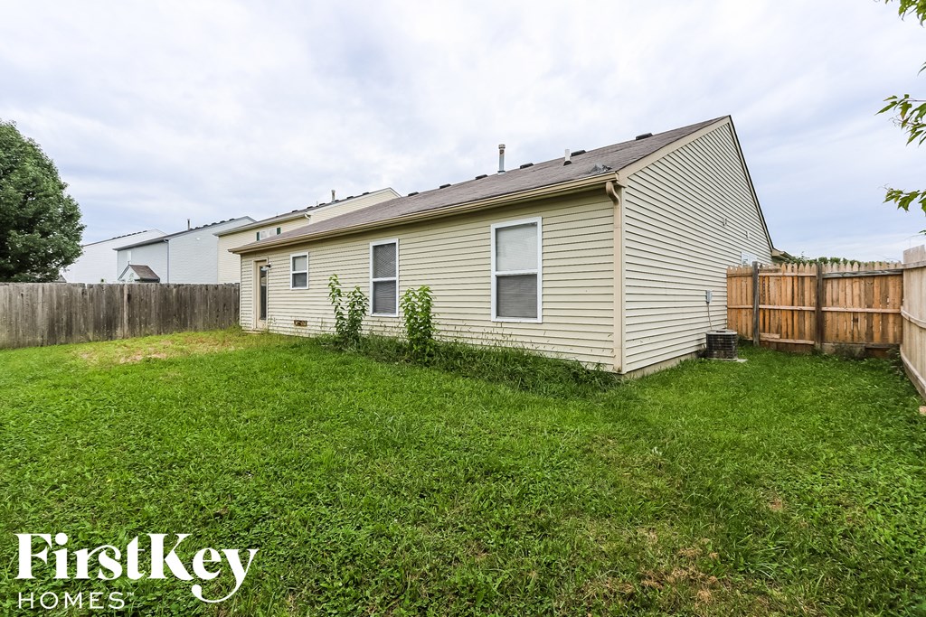 the backyard of a house with a yard and a fence