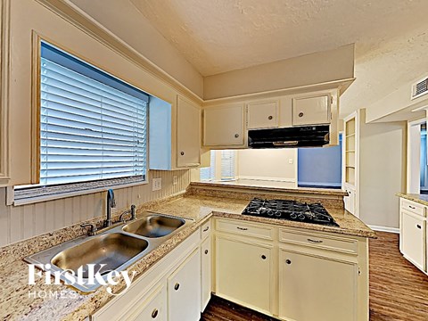 A kitchen with a granite countertop and a stove top oven.