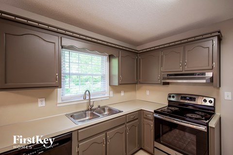 a kitchen with gray cabinets and stainless steel appliances