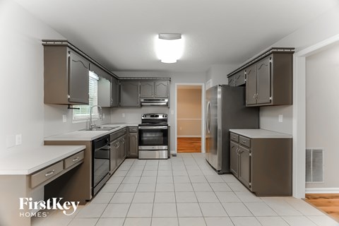 A kitchen with a tile floor and a range hood.