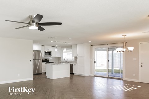 A spacious kitchen with a fan and a view of the backyard.