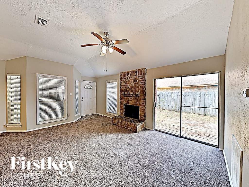 A room with a fireplace and a ceiling fan.