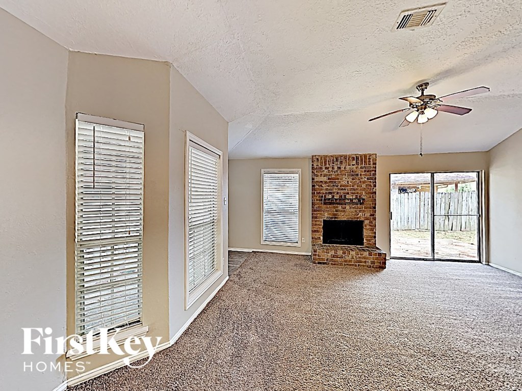 A room with a fireplace and a ceiling fan.