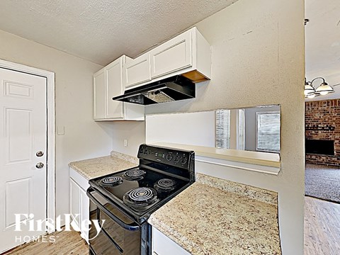 A kitchen with a stove top oven and a window.