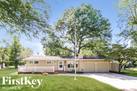the exterior of a house with a lawn and trees