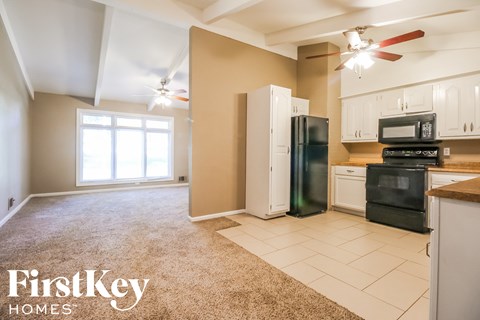 a kitchen with white cabinets and black appliances