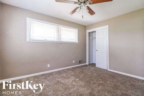 a bedroom with carpet and a ceiling fan