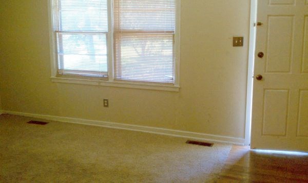 an empty room with a window and a door