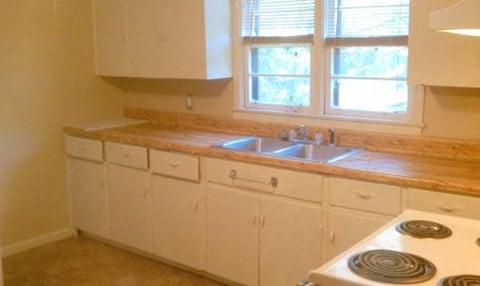 a kitchen with a stove and a sink and a window